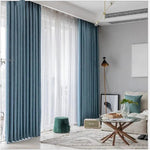 Rideaux élégants bleus pour salon moderne, décoration intérieure épurée avec fauteuil confortable, table basse en bois, pouf vert et lampe design pour un espace de vie lumineux et accueillant.
