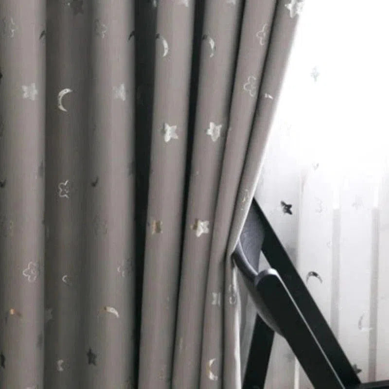 Rideau occultant gris élégant avec motifs d'étoiles et de lunes, idéale pour chambre à coucher. Ce rideau moderne ajoute une touche de décoration céleste tout en améliorant l'intimité et le confort thermique de votre espace. Parfait pour créer une ambiance apaisante et stylée.