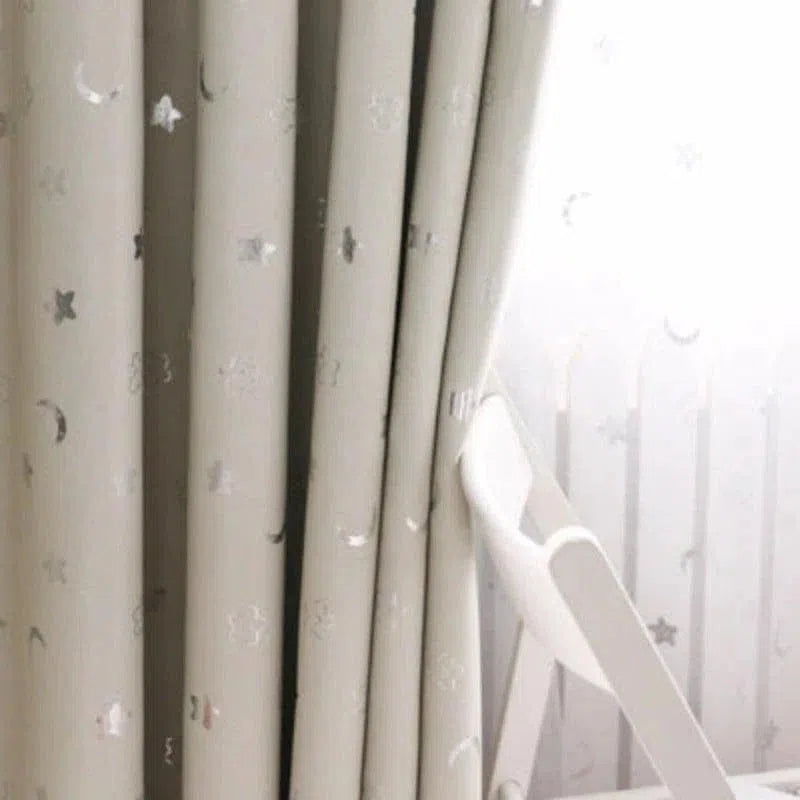 Rideaux occultants pour chambre d'enfant avec motifs étoiles et lunes, idéal pour créer une ambiance apaisante et favoriser le sommeil. Design élégant et contemporain, parfait pour ajouter une touche décorative à la pièce tout en bloquant efficacement la lumière. Accessoire essentiel pour un aménagement intérieur cosy et fonctionnel.