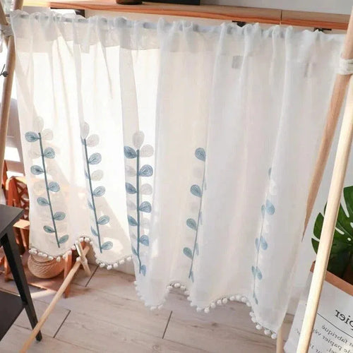 Rideau élégant avec motif floral bleu et bordure à pompons, idéal pour apporter une touche de charme à la décoration intérieure. Parfait pour filtrer la lumière tout en ajoutant une note décorative à n'importe quelle pièce de la maison. Accessoire déco tendance pour salon ou chambre.