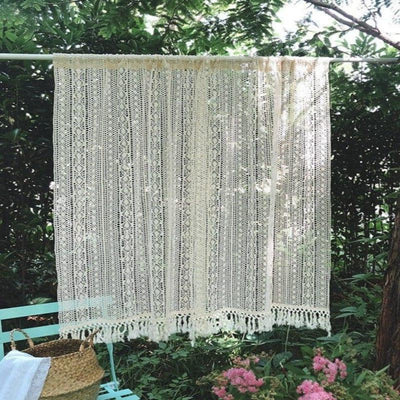 Rideau élégant suspendu dans un jardin fleuri, parfait pour créer une ambiance naturelle et apaisante. Idéal pour décorer une terrasse ou un espace extérieur avec style. Accessoire décoratif qui filtre doucement la lumière tout en préservant l'intimité.