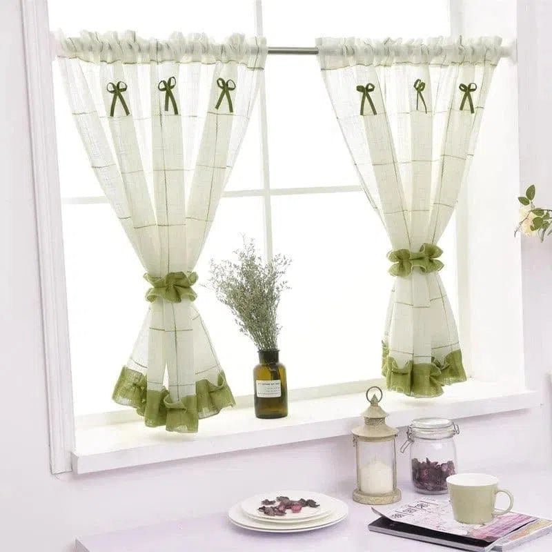 Rideaux décoratifs légers pour fenêtre, ornés de rubans verts, parfaits pour ajouter une touche élégante à votre cuisine ou salon. Design avec des détails de nœuds qui apportent charme et modernité à votre intérieur. Accessoire idéal pour laisser entrer la lumière tout en préservant l'intimité.