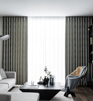 Salon moderne avec rideaux élégants encadrant une fenêtre lumineuse, mettant en valeur un décor intérieur épuré. Canapé confortable et table basse contemporaine assortis pour un espace de vie chic et harmonieux. Ambiance accueillante avec fauteuil design et accessoires décoratifs sophistiqués.