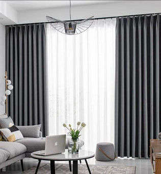 Rideaux élégants pour salon moderne, harmonie parfaite avec un canapé gris et des accessoires décoratifs contemporains, offrant une ambiance chic et raffinée. Luminosité douce idéale pour l'intérieur.