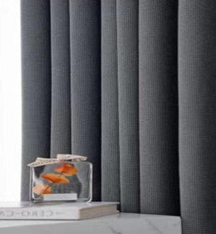 Rideaux opaques gris modernes dans un intérieur minimaliste, ajoutant une touche d'élégance. Parfait pour une décoration de salon ou de chambre à coucher. Complétés par un élément décoratif en verre sur une surface blanche pour un style raffiné.