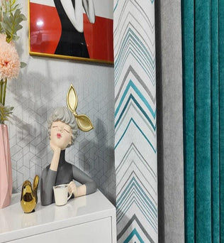 Décoration intérieure moderne avec rideaux multicolores et motifs géométriques, assortis à des éléments décoratifs élégants sur une commode blanche, comprenant une sculpture artistique et un vase contemporain avec des fleurs. Ambiance design et originale pour un salon style contemporain.