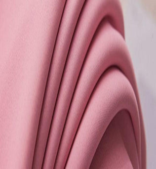 Image montrant un tissu rose drapé élégamment, idéal pour des créations de mode tendance. Ce textile aux plis harmonieux ajoute une touche de douceur et de modernité aux projets de couture et décoration.