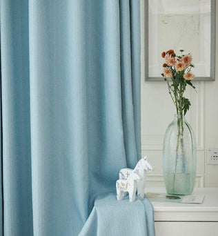 Rideaux bleu doux pour décoration intérieure, idéal pour votre salon ou chambre. Apportez une touche d'élégance avec ces rideaux élégants, complétés par un vase élégant contenant des fleurs fraîchement coupées. Transformez votre espace de vie avec style et sophistication.