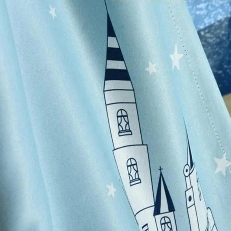 Rideau bleu avec motif de château et étoiles blanches, idéal pour une chambre d'enfant à thème féerique. Ce design captivant ajoute une touche de magie et de rêve à la décoration intérieure, créant une ambiance apaisante et enchantée. Parfait pour personnaliser et embellir la chambre des petits rêveurs.
