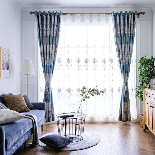 Rideaux élégants bleu et blanc dans un salon moderne avec canapé confortable, décoration végétale et lumière naturelle. Ambiance chaleureuse et accueillante.