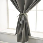 Rideau moderne gris pour décoration intérieure, ajoute élégance à toute pièce, idéal pour salon et chambre, noué avec embrasse à franges pour un style raffiné.