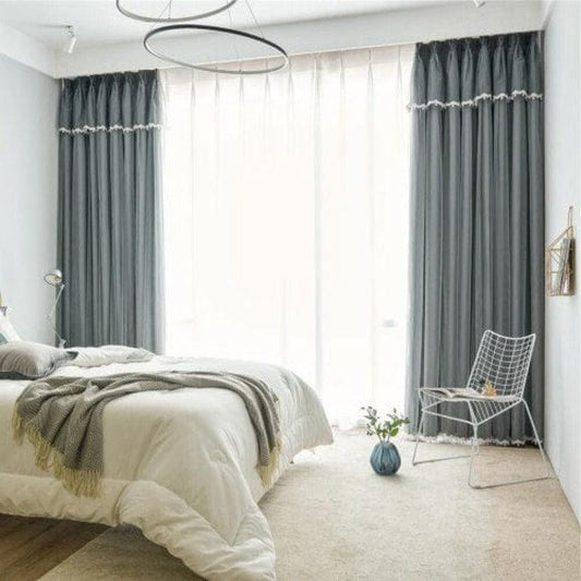 Chambre moderne avec rideaux opaques gris offrant une ambiance apaisante. Chambre à coucher lumineuse dotée d'une grande fenêtre et d'un lit confortable. Espace de vie élégant avec décoration épurée et chaise design. Parfait pour améliorer l'intimité et le confort de votre intérieur. Idéal pour un style contemporain et cosy.