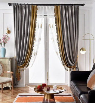 Paire de rideaux élégants dans un salon moderne avec canapé noir, table basse dorée et éclairage élégant. Les rideaux gris et dorés encadrent une fenêtre lumineuse, ajoutant une touche de sophistication à l'intérieur. Décoration chic avec des fleurs dans un vase bleu et une ambiance chaleureuse et accueillante. Parfait pour l'amélioration de votre espace de vie.