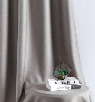 Rideau élégant et moderne dans un intérieur minimaliste, accompagné de livres et d'une décoration tendance, parfait pour sublimer votre salon ou chambre avec une touche contemporaine.