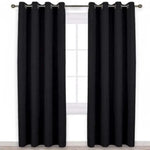 Rideau occultant noir élégant suspendu devant une fenêtre. Idéal pour bloquer la lumière et offrir une isolation thermique dans votre salon ou chambre. Design moderne avec œillets métalliques pour une installation facile. Parfait pour ajouter une touche sophistiquée à votre intérieur.