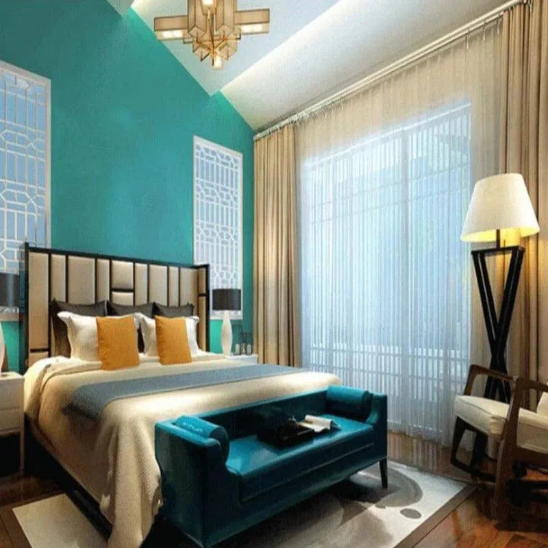 Chambre moderne et élégante avec un grand lit double, un banc turquoise au pied du lit et une décoration intérieure raffinée. Parfaitement illuminée par une grande fenêtre avec rideaux transparents, cette chambre offre une atmosphère confortable avec un lampadaire design et des accents colorés. Ideal pour un aménagement intérieur sophistiqué.