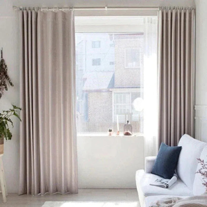 Rideau beige élégant pour salon moderne, accroché devant une grande fenêtre, offrant une ambiance lumineuse et accueillante. Le design minimaliste rehausse la décoration intérieure et crée un espace chaleureux et convivial.