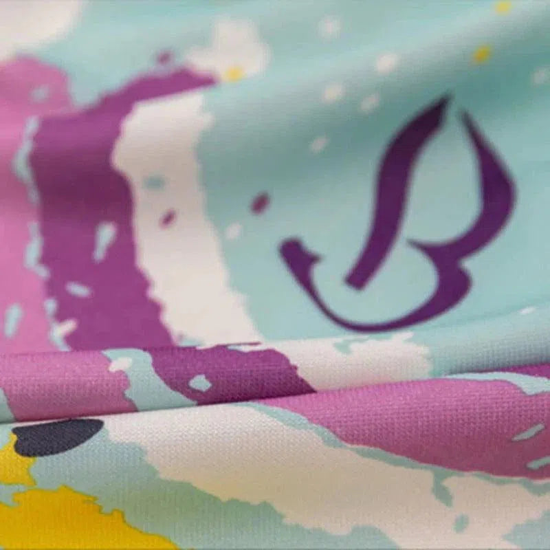 Image d'un tissu aux motifs artistiques colorés, incluant des teintes de violet, turquoise et jaune. Le design présente un motif abstrait avec des formes et des lignes fluides, ajoutant une touche moderne et vibrante. Ideal pour créer des vêtements ou des accessoires tendance.