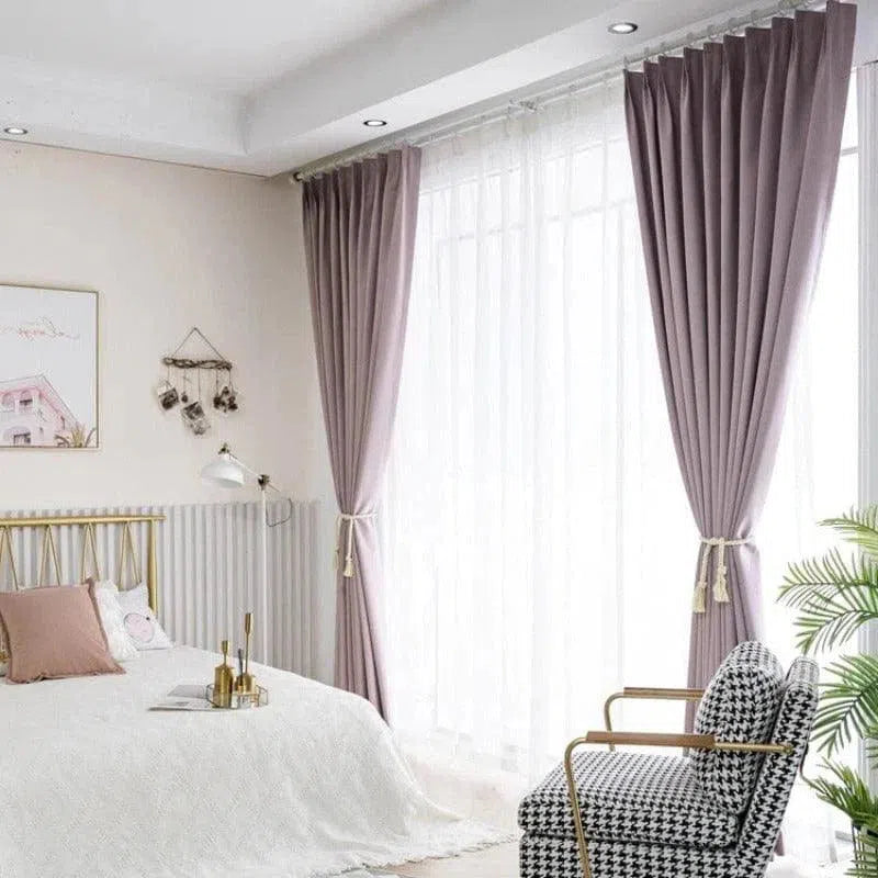 Chambre moderne avec rideaux élégants et luminaires encastrés, comprenant un lit aux tons clairs et un fauteuil au motif noir et blanc. Idéale pour un intérieur lumineux et sophistiqué. Décoration avec des cadres artistiques et un espace bien agencé pour un confort maximal.
