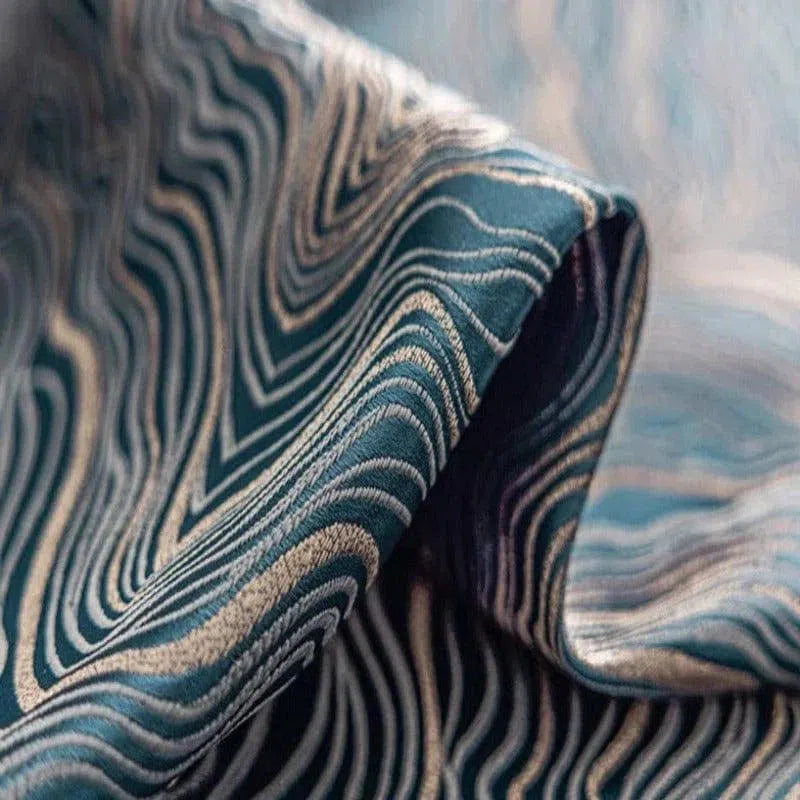 Image d'un tissu élégant avec des motifs ondulés bleu marine et beige, idéal pour la décoration intérieure et la création de vêtements modernes. Design unique et esthétique qui apporte une touche artistique et sophistiquée à tout projet de couture ou d'aménagement. Parfait pour les amateurs de style contemporain et raffiné.