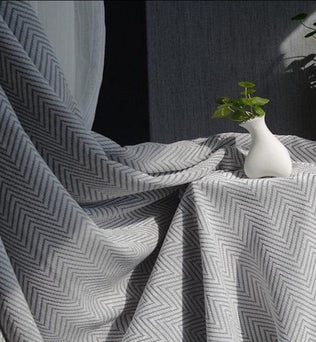 Rideau gris à motifs chevrons, idéal pour une décoration intérieure moderne et élégante. Ce tissu occultant et isolant offre une ambiance cosy tout en préservant votre intimité. Parfait pour le salon ou la chambre, il est mis en valeur par la douce lumière naturelle de la pièce. Accessoire déco raffiné, ce rideau complète à merveille votre espace de vie.