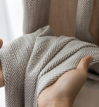 Rideau en tissu texturé, motif chevron gris et blanc, présenté en gros plan. Idéal pour ajouter une touche d'élégance et de modernité à votre intérieur. Fabriqué à partir de matériaux de haute qualité pour une durabilité et un style intemporel. Parfait pour le salon, la chambre ou tout autre espace de vie.