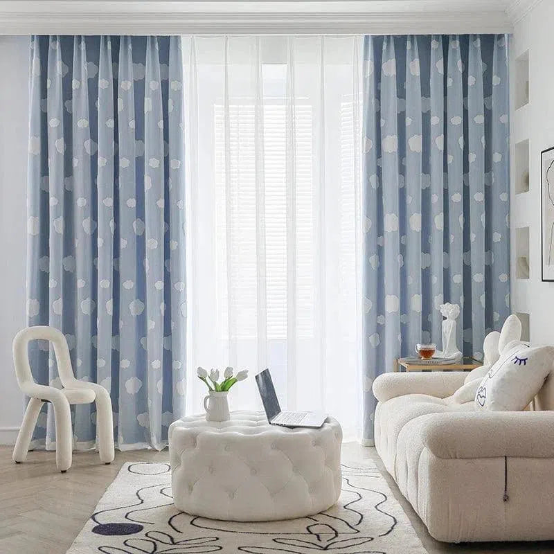 Rideaux bleus à motifs pour salon moderne, apportant une touche élégante et lumineuse à votre intérieur. Ils encadrent une fenêtre large, permettant une diffusion douce de la lumière naturelle. Parfait pour un aménagement contemporain et accueillant.