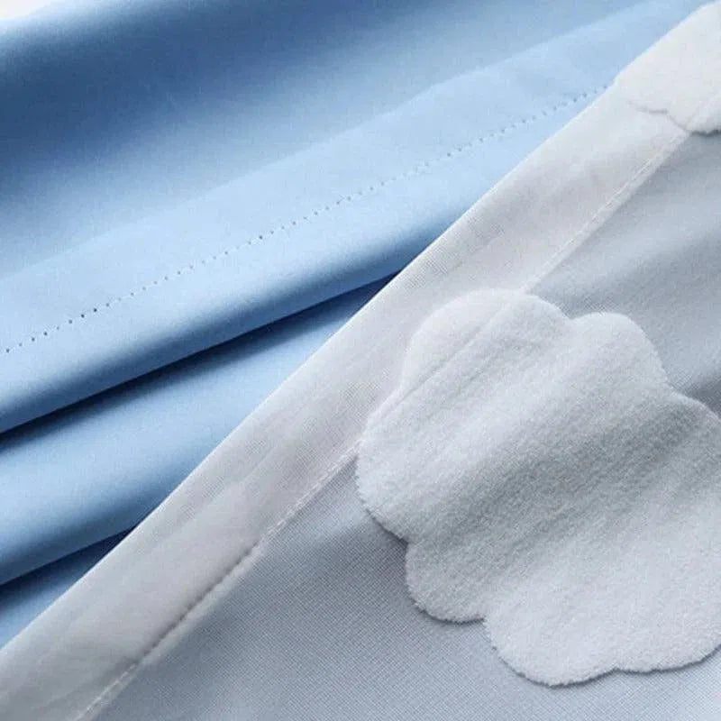Drap bleu ciel pour lit d'enfant avec motif de nuages blancs, idéal pour créer une ambiance douce et apaisante dans la chambre. Parfait pour un décor de chambre thématique sur le ciel ou les rêves d'enfance.