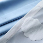 Drap bleu ciel pour lit d'enfant avec motif de nuages blancs, idéal pour créer une ambiance douce et apaisante dans la chambre. Parfait pour un décor de chambre thématique sur le ciel ou les rêves d'enfance.