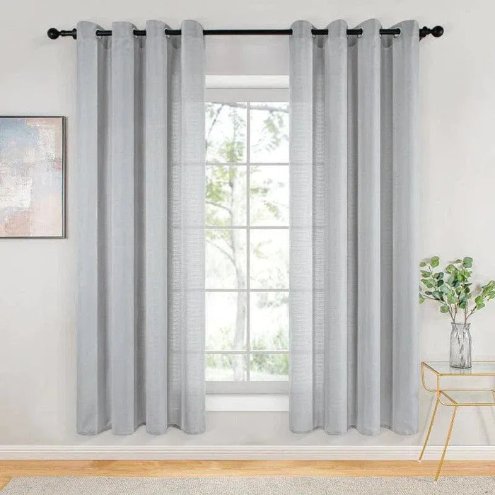 Rideau moderne gris clair accroché à une tringle noire dans un salon lumineux. Design élégant avec une touche contemporaine pour décorer vos fenêtres et sublimer votre intérieur. Idéal pour améliorer la luminosité tout en préservant l'intimité de l'espace.