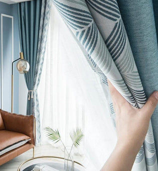 Rideaux élégants bleus avec motifs géométriques, ajoutant une touche de style moderne à un salon lumineux. Accessoire idéal pour améliorer la décoration intérieure et contrôler la luminosité. Convient parfaitement pour un cadre chaleureux et convivial.