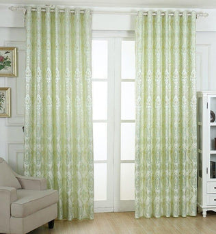 Rideaux élégants vert clair avec motifs subtils pour salon moderne, suspendus à une tringle au-dessus d'une grande fenêtre, apportant une touche raffinée et lumineuse à la décoration intérieure. Ideal pour filtrer la lumière tout en ajoutant du style à votre espace de vie.