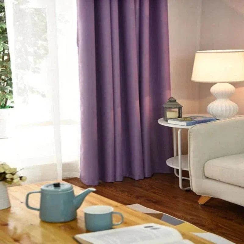 Rideau violet élégant dans un salon moderne, combinant des éléments de décoration raffinée avec une table basse en bois, une théière et une tasse assortie, créant une ambiance chaleureuse et invitante. Idéal pour ajouter une touche de couleur et de style à votre intérieur.