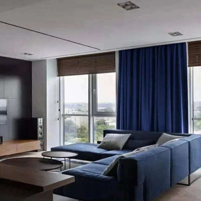 Rideau bleu élégant pour salon moderne, apportant une touche de sophistication et d'intimité, idéal pour les grandes fenêtres dans un intérieur contemporain avec mobilier assorti.
