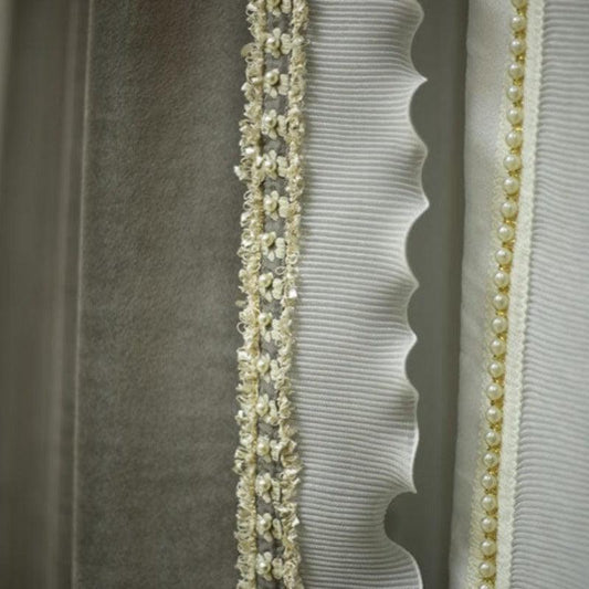 Élégant rideau décoratif blanc avec détails perlés et bordures festonnées, idéal pour ajouter une touche sophistiquée à votre intérieur.