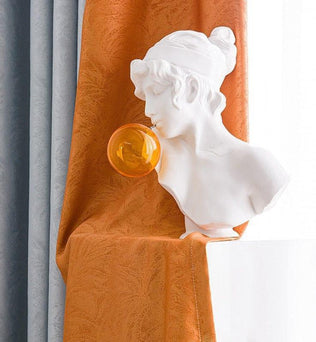 Buste décoratif moderne à bulles dans un intérieur élégant, accentué par des rideaux orange et gris. Accessoire unique pour sublimer votre décoration intérieure avec une touche artistique et contemporaine. Idéal pour les amateurs de design innovant et sophistiqué.