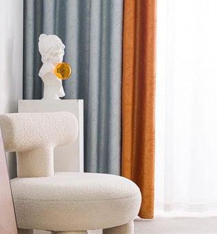 Fauteuil design moderne et élégant dans un intérieur chic, avec rideaux colorés en arrière-plan apportant une touche chaleureuse et artistique. Statue décorative sur un piédestal ajoutant une aura artistique et contemporaine au décor. Idéal pour un salon raffiné ou un espace de travail créatif.