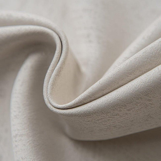 Gros plan d'un tissu élégant beige, idéal pour confection et ameublement, mettant en valeur des plis subtils et une texture délicate. Accessoire indispensable pour décoration intérieure.