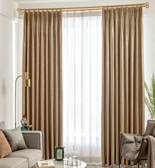 Rideaux élégants couleur beige dans un salon moderne, apportant une touche sophistiquée à la décoration intérieure. Les rideaux tombent gracieusement du plafond au sol, encadrant une grande fenêtre. Le salon est orné de meubles contemporains avec un canapé beige, une lampe dorée et des plantes vertes pour un espace accueillant et harmonieux.