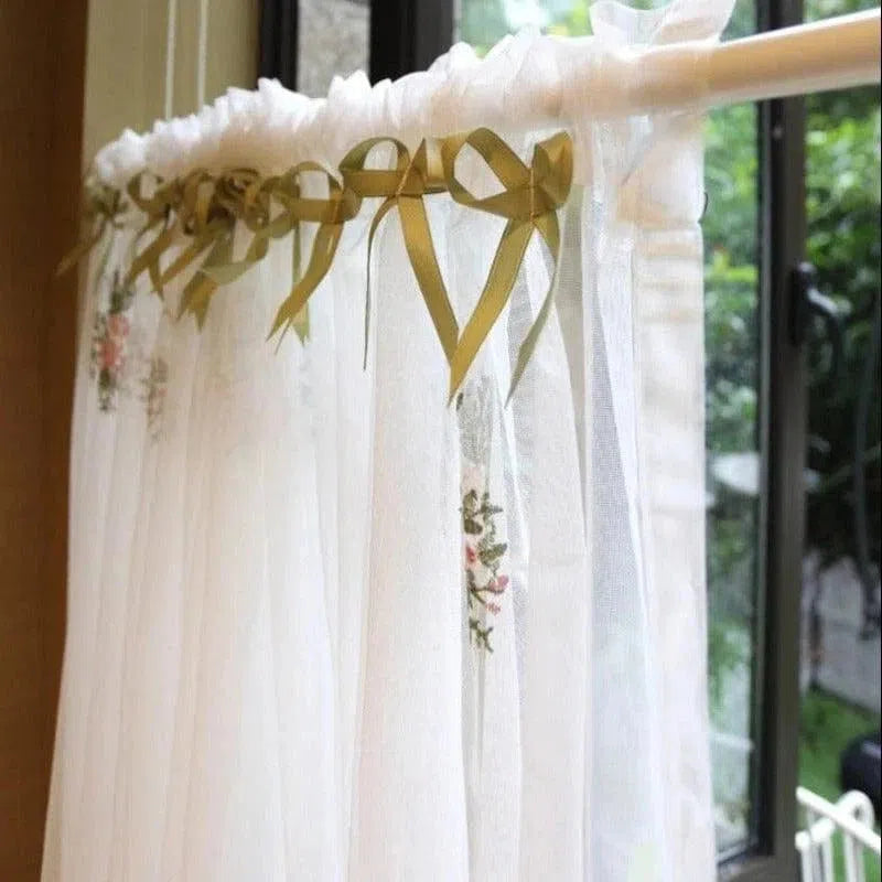 Rideau déco élégant avec rubans ornés de motifs floraux, idéal pour une ambiance romantique dans une chambre ou un salon. Ce rideau blanc laisse passer la lumière tout en ajoutant une touche de charme classique à votre intérieur. Parfait pour les fenêtres modernes, il crée une atmosphère douce et accueillante.