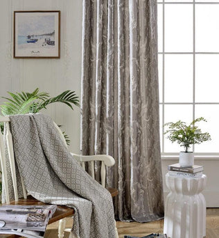 Rideaux élégants gris clair avec motifs subtils pour salon moderne, ambiance lumineuse et accueillante. Décoration intérieure avec plante verte, tableau mural et éléments de design contemporain.