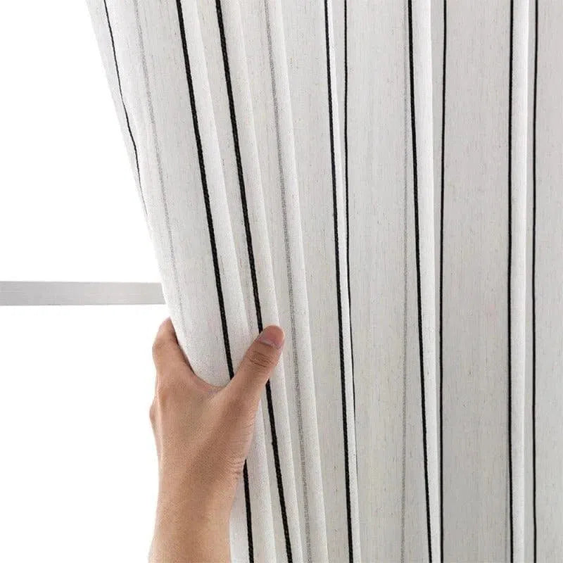 Rideau blanc à rayures verticales noires, idéal pour une décoration intérieure moderne et élégante. Design épuré parfait pour embellir un salon ou une chambre. Facile à installer et à entretenir.