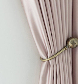 Rideau élégant beige clair attaché avec un embrasse en métal doré, idéale pour une décoration intérieure sophistiquée. Parfait pour apporter une touche de luxe et de fonctionnalité à tout salon ou chambre à coucher.