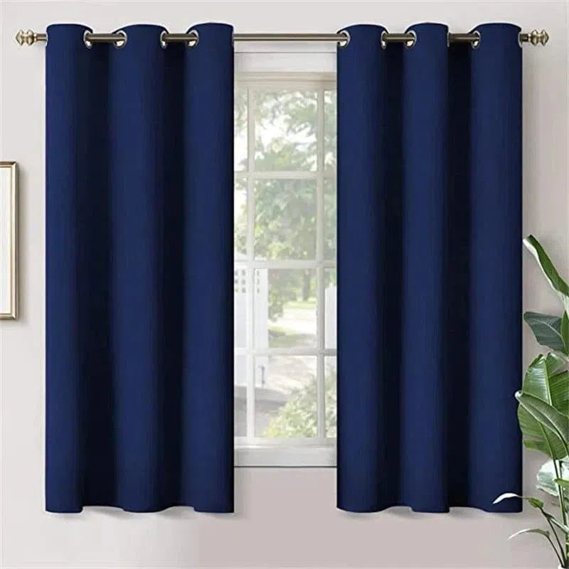 Rideau occultant bleu marine avec œillets monté sur une tringle. Design moderne et élégant pour salon ou chambre. Taille ajustable pour fenêtres standards. Décoration intérieure chic et pratique pour réguler la lumière naturelle.