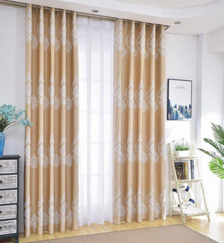 Rideaux élégants avec motifs décoratifs placés dans un salon lumineux. Décoration intérieure raffinée comprenant des rideaux beiges aux motifs blancs, accentuant une ambiance moderne et chaleureuse. Accessoires tendance complétant le design, tels qu'un meuble de rangement et des plantes d'intérieur, créant un espace accueillant et harmonieux. Fenêtre baignée de lumière naturelle, idéale pour les pièces à vivre contemporaines.