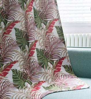 Tissu décoratif aux motifs feuillus exotiques avec des tons de rouge et vert, idéal pour apporter une touche tropicale et colorée à votre intérieur. Transformez votre salon ou votre chambre grâce à cet accessoire tendance et élégant.