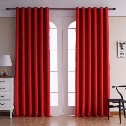 Rideau rouge élégant pour salon, suspendu devant une porte-fenêtre. Design moderne avec œillets. Accessoire décoratif idéal pour une ambiance chaleureuse et contemporaine dans votre intérieur. Parfait pour ajouter une touche de couleur à votre décoration.