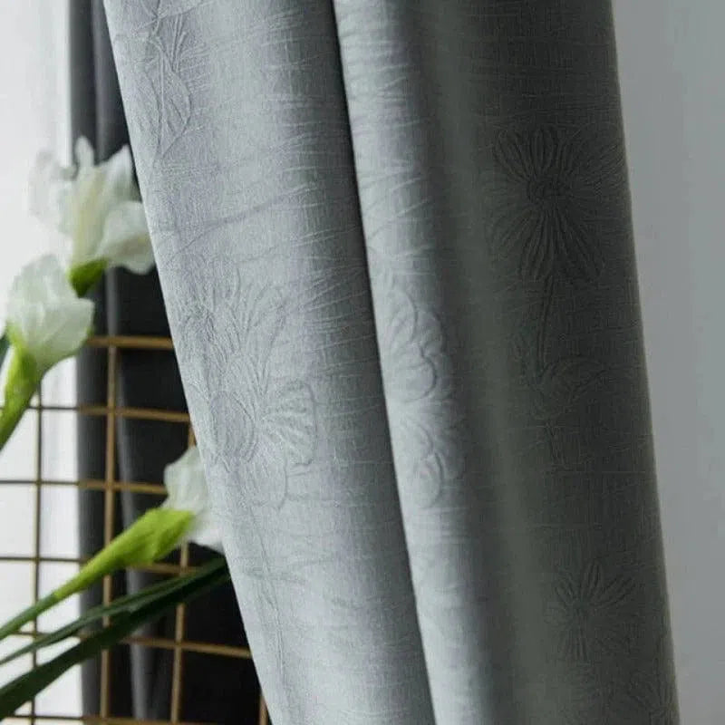 Rideau gris élégant avec motifs floraux en relief, ajoutant une touche sophistiquée à votre intérieur. Parfait pour créer une ambiance chaleureuse et moderne, tout en offrant une excellente gestion de la luminosité. Accessoirisez votre salon ou chambre avec ce design raffiné.