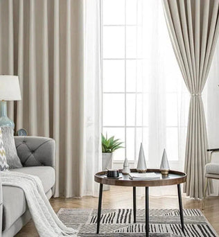 Rideaux élégants pour salon moderne, encadrant une large fenêtre avec lumière naturelle. Ambiance épurée avec canapé confortable, table basse design et décoration minimaliste. Idéal pour un intérieur chic et contemporain. Décoration d'intérieur harmonieuse avec couleurs neutres et motifs géométriques.