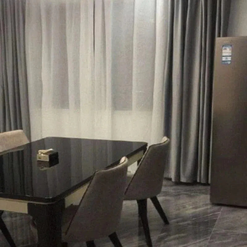 Salle à manger moderne avec table élégante et chaises confortables, offrant un espace convivial pour les repas en famille. Le design contemporain s'harmonise avec les rideaux et le sol, créant une ambiance sophistiquée. Idéal pour améliorer votre intérieur avec style et fonctionnalité.